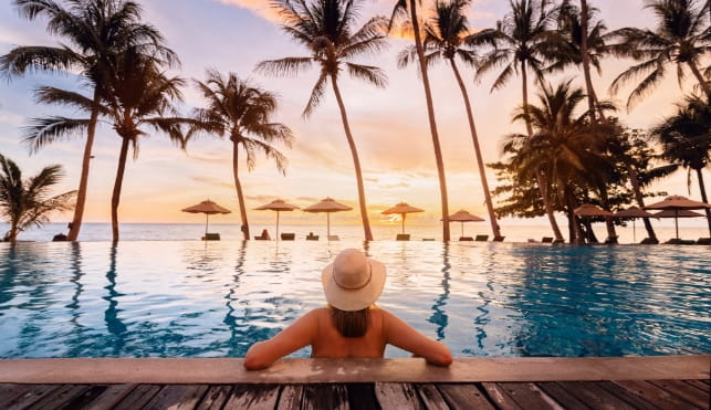 Woman in a pool looking at a beach